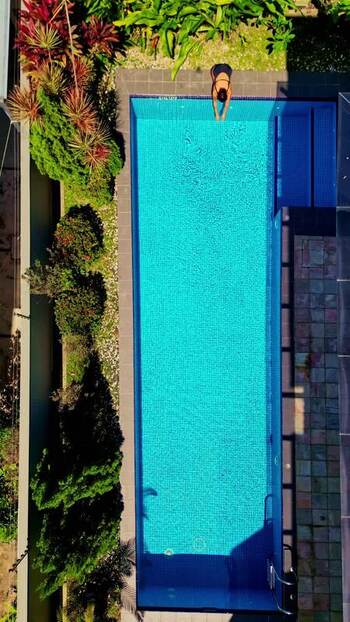 Aerial view of a person by a swimming pool Malaysia.