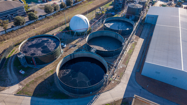 Aerial view of Water Treatment Centre Camberley featuring large circular storage tanks and a spherical gas holder surrounded by industrial infrastructure in Camberley England United Kingdom. Aerial view of Water Treatment Centre Camberley featuring large circular storage tanks and a spherical gas holder surrounded by industrial infrastructure in Camberley England United Kingdom.