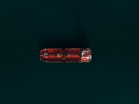 Aerial view of a red industrial tanker ship floating on the dark blue waters of the Mediterranean Sea Augusta Sicily Italy. Aerial view of a red industrial tanker ship floating on the dark blue waters of the Mediterranean Sea Augusta Sicily Italy.