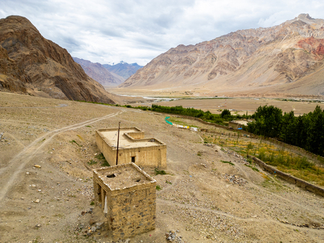 Aerial view of traditional stone buildings and dirt paths set against the rugged mountain landscape of the Zanskar valley Zanskar Ladakh India.