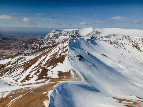 Aerial view of the snow covered Moskardhshnukar mountain peaks with rocky ridges and vast winter landscapes in Mosfellsbaer Kjosarhreppur Iceland. Aerial view of the snow covered Moskardhshnukar mountain peaks with rocky ridges and vast winter landscapes in Mosfellsbaer Kjosarhreppur Iceland.