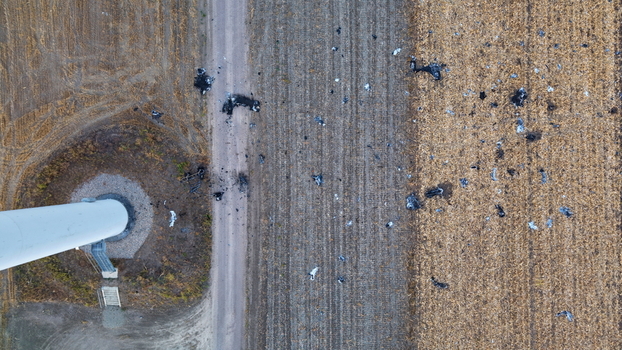 Aerial view of wind turbine debris scattered across an agricultural field next to a turbine base in Vladimirovac Vojvodina Serbia.