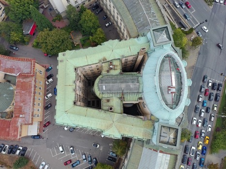Aerial view of Sofia University St. Kliment Ohridski with its green copper roof and central dome surrounded by urban streets and parking in Sofia Sofia City Province Bulgaria.