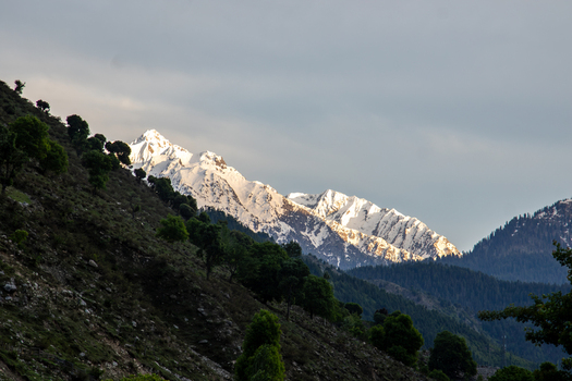 View of snow capped mountain peaks rising above forested slopes in Kumrat Valley Khyber Pakhtunkhwa Pakistan. View of snow capped mountain peaks rising above forested slopes in Kumrat Valley Khyber Pakhtunkhwa Pakistan.