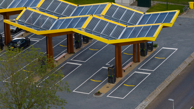 Oostzaan Netherlands 09 June 2026 Aerial view of Fastned Charging Station with solar panel canopy electric vehicle charging points and paved parking area.