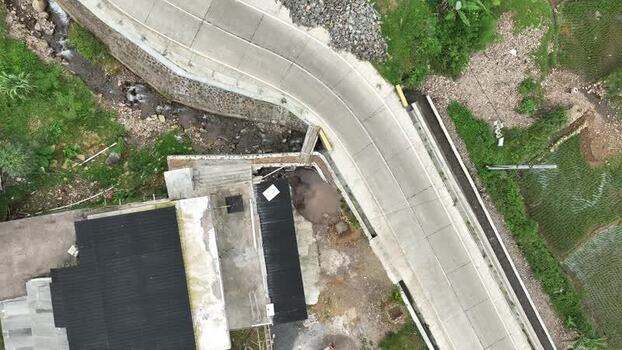 Aerial view of a curved road near Rawa Gede Jonggol Lake Indonesia.