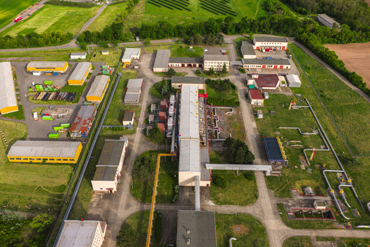 Aerial view of an industrial facility with pipelines and storage buildings surrounded by green fields in Hrusky South Moravian Region Czechia. Aerial view of an industrial facility with pipelines and storage buildings surrounded by green fields in Hrusky South Moravian Region Czechia.
