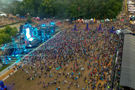 Herzogenaurach Germany 26 July 2025 Aerial view of the Open Beatz Festival featuring a massive main stage large crowds of people and surrounding forest area.