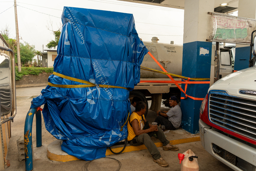 San Jose Northern Mariana Islands 05 July 2026 View of people resting near a water tanker covered with a blue Samaritan s Purse tarp at a gas station in San Jose. San Jose Northern Mariana Islands 05 July 2026 View of people resting near a water tanker covered with a blue Samaritan s Purse tarp at a gas station in San Jose.