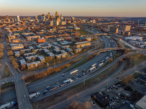 Aerial view of a bustling city where the highway weaves through buildings under the soft glow of the setting sun Kansas City USA. Aerial view of a bustling city where the highway weaves through buildings under the soft glow of the setting sun Kansas City USA.