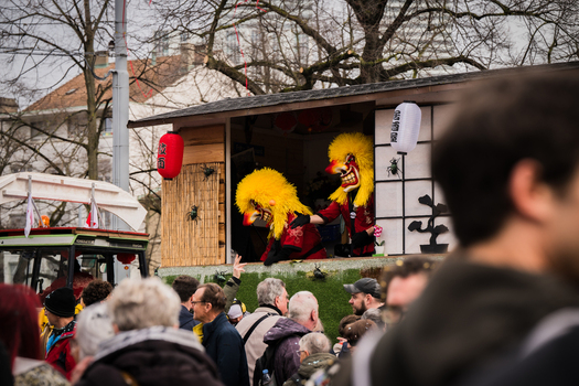 Basel Switzerland 10 March 2025 View of vibrant yellow masked figures performing on a traditional Japanese style stage during the Fasnacht festival amidst a crowd of onlookers. Basel Switzerland 10 March 2025 View of vibrant yellow masked figures performing on a traditional Japanese style stage during the Fasnacht festival amidst a crowd of onlookers.