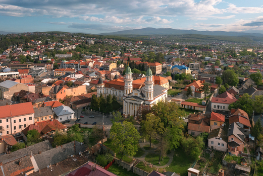 Aerial view of the Cathedral of the Exaltation of the Holy Cross rises majestically amidst a tapestry of terracotta rooftops and verdant trees Uzhhorod Zakarpattia Oblast Ukraine. Aerial view of the Cathedral of the Exaltation of the Holy Cross rises majestically amidst a tapestry of terracotta rooftops and verdant trees Uzhhorod Zakarpattia Oblast Ukraine.
