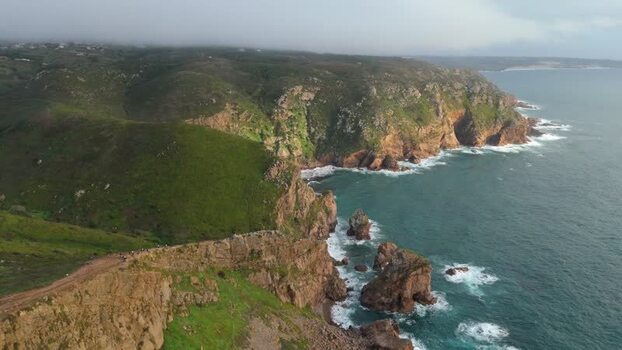 Aerial view of Cape Roca Lighthouse and rugged cliffs Portugal.