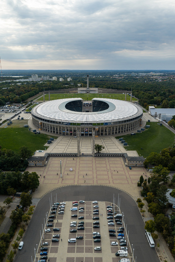 Berlin Germany 26 September 2026 Aerial view of Olympiastadion Berlin with its iconic circular architecture surrounding green spaces and parking area.
