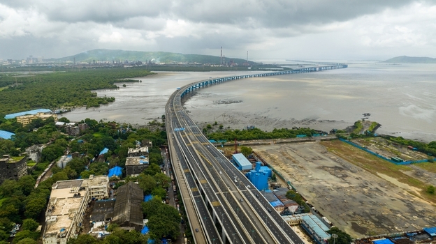 Aerial view of Atal Bihari Vajpayee Sewri Nhava Sheva Atal Setu stretching across the bay with lush mangroves urban infrastructure and a cloudy sky in Mumbai Maharashtra India. Aerial view of Atal Bihari Vajpayee Sewri Nhava Sheva Atal Setu stretching across the bay with lush mangroves urban infrastructure and a cloudy sky in Mumbai Maharashtra India.