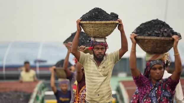 View of workers carrying coal baskets in Aminbazar Bangladesh. View of workers carrying coal baskets in Aminbazar Bangladesh.