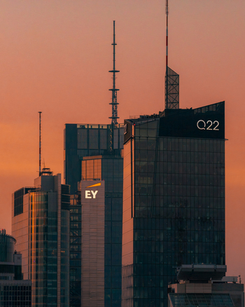 Warsaw Poland 01 March 2026 Aerial view of the Q22 and EY skyscrapers in the business district against a warm orange sunset sky.
