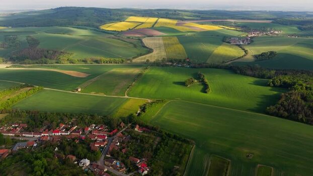 Aerial view of rolling green fields and a small village Czechia. Aerial view of rolling green fields and a small village Czechia.