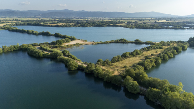 Aerial view of the Extraccion de aridos Lima S.L gravel extraction site with water reservoirs lush vegetation and rolling hills in Vilarino das Poldras Ourense Spain. Aerial view of the Extraccion de aridos Lima S.L gravel extraction site with water reservoirs lush vegetation and rolling hills in Vilarino das Poldras Ourense Spain.