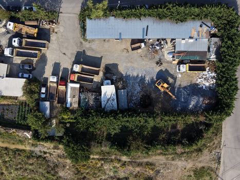 Aerial view of a construction yard with dump trucks an excavator and debris piles surrounded by dense hedges Istanbul Istanbul Turkiye.