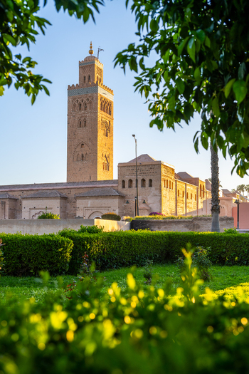 View of the Koutoubia Mosque minaret rising above lush green garden hedges in the historic city center of Marrakesh Marrakesh Safi Morocco. View of the Koutoubia Mosque minaret rising above lush green garden hedges in the historic city center of Marrakesh Marrakesh Safi Morocco.