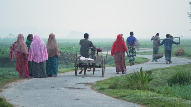 View of people walking on a rural road in Bogura Bangladesh.