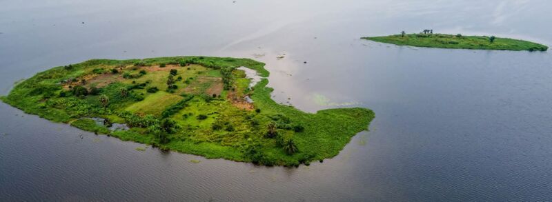 Aerial view of lush green islands with palm trees and vegetation surrounded by calm water in Ghana. Aerial view of lush green islands with palm trees and vegetation surrounded by calm water in Ghana.