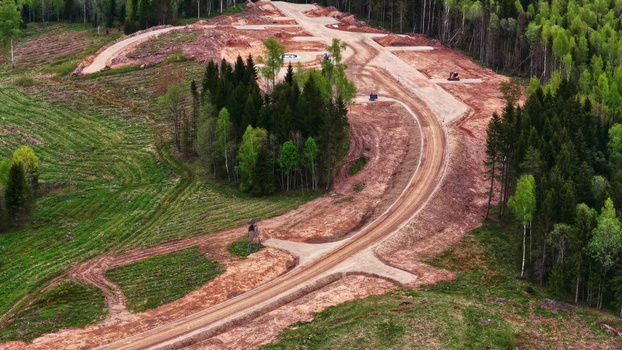 Aerial view of wind turbine base construction site with cleared land dirt roads and surrounding forest in Latvia. Aerial view of wind turbine base construction site with cleared land dirt roads and surrounding forest in Latvia.