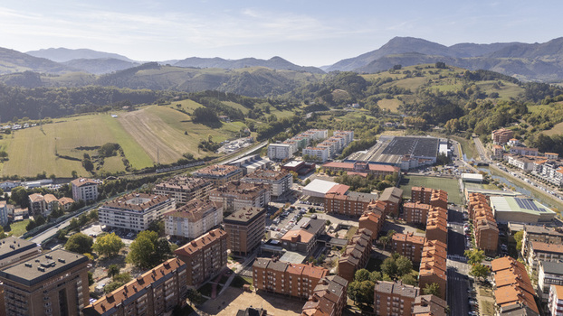 Aerial view of the town of Zumaia with its characteristic residential buildings orange rooftops and surrounding green hills under a clear sky in Zumaia Basque Country Spain.
