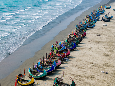 Cox s Bazar Bangladesh 10 March 2026 Aerial view of colorful moon shaped fishing boats lined up on the sandy shore of the beach with turquoise ocean waves. Cox s Bazar Bangladesh 10 March 2026 Aerial view of colorful moon shaped fishing boats lined up on the sandy shore of the beach with turquoise ocean waves.