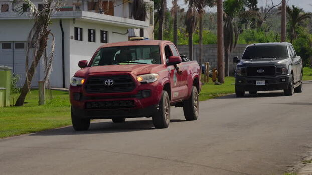 View of pickup trucks on a road in San Jose Northern Mariana Islands. View of pickup trucks on a road in San Jose Northern Mariana Islands.