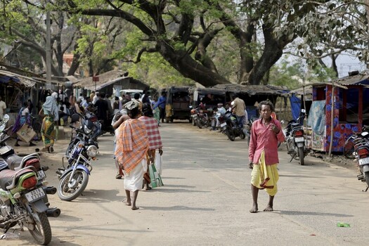 Odisha India 26 March 2026 View of a bustling street scene with vibrant colors and textures where locals and motorbikes converge under the shade of sprawling trees. Odisha India 26 March 2026 View of a bustling street scene with vibrant colors and textures where locals and motorbikes converge under the shade of sprawling trees.