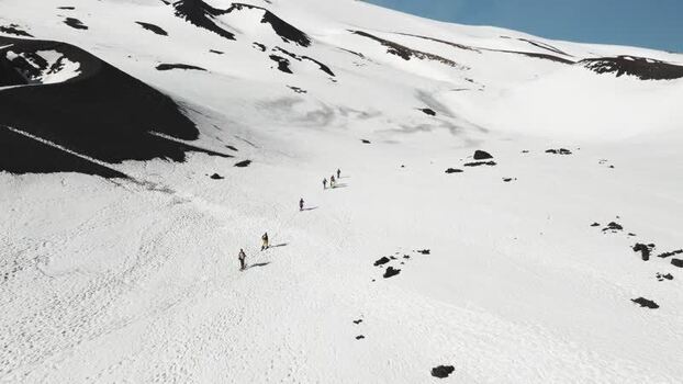 Aerial view of hikers walking on the snowy slopes of Mount Etna Italy. Aerial view of hikers walking on the snowy slopes of Mount Etna Italy.