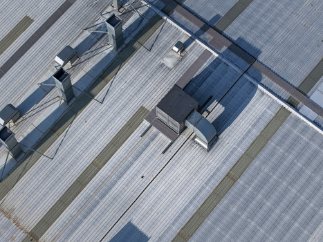 Aerial view of the industrial factory roof in Kilsyth South featuring metallic corrugated panels ventilation units and structural vents in Melbourne VIC Australia. Aerial view of the industrial factory roof in Kilsyth South featuring metallic corrugated panels ventilation units and structural vents in Melbourne VIC Australia.