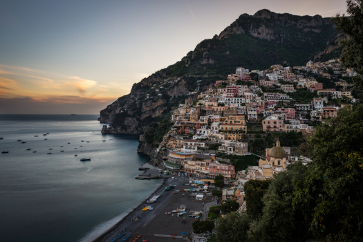 View of the colorful houses of Positano clinging to the steep cliffs above the beach and sea at sunset Positano Campania Italy. View of the colorful houses of Positano clinging to the steep cliffs above the beach and sea at sunset Positano Campania Italy.