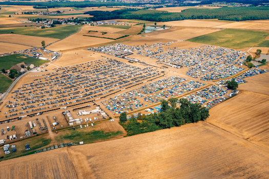 Herzogenaurach Germany 22 July 2022 Aerial view of the Open Beatz Festival campsite with rows of tents and parked cars surrounded by agricultural fields. Herzogenaurach Germany 22 July 2022 Aerial view of the Open Beatz Festival campsite with rows of tents and parked cars surrounded by agricultural fields.