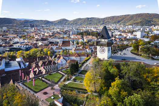 Aerial view of the iconic clock tower the Grazer Uhrturm stands proudly above the autumnal hues of the city a testament to time and tradition Graz Styria Austria.