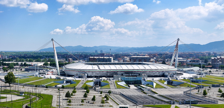 Torino Italy 09 May 2026 Aerial view of Allianz Stadium featuring its modern architecture suspension cables and surrounding parking lots with hills in the background.