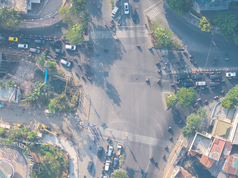 Surabaya East Java Indonesia 05 August 2026 Aerial view of a busy urban intersection with heavy traffic cars motorcycles and pedestrians crossing the street.