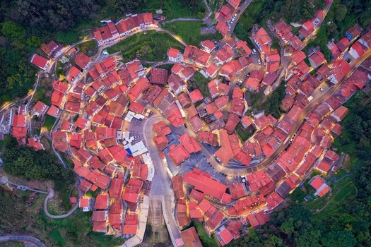 Aerial view of the historic village of Cudillero with its iconic red tiled rooftops and winding streets illuminated by warm streetlights at dusk Cudillero Asturias Spain. Aerial view of the historic village of Cudillero with its iconic red tiled rooftops and winding streets illuminated by warm streetlights at dusk Cudillero Asturias Spain.