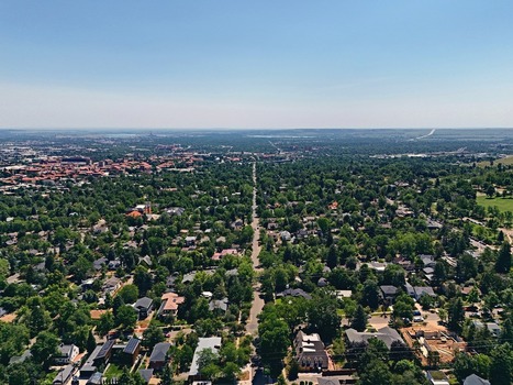 Aerial view of Chautauqua Park and the surrounding residential neighborhood with lush green trees suburban houses and clear blue sky in Boulder Colorado United States. Aerial view of Chautauqua Park and the surrounding residential neighborhood with lush green trees suburban houses and clear blue sky in Boulder Colorado United States.
