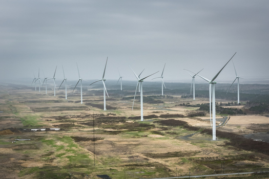 Aerial view of wind turbines standing in a vast open field under a cloudy sky in Wakkanai Hokkaido Japan.