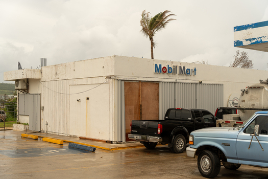 San Jose Tinian Northern Mariana Islands 05 July 2026 View of a Mobil Mart convenience store with boarded up windows and parked pickup trucks under a cloudy sky. San Jose Tinian Northern Mariana Islands 05 July 2026 View of a Mobil Mart convenience store with boarded up windows and parked pickup trucks under a cloudy sky.