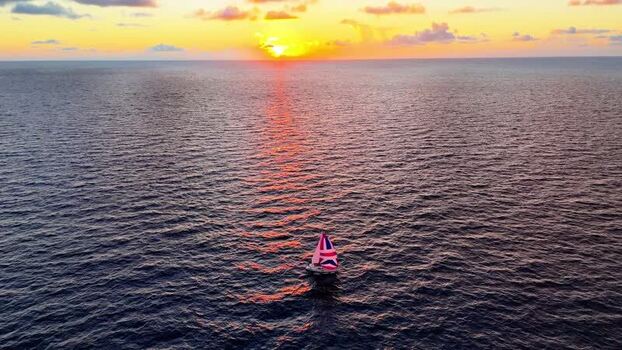 Aerial view of a sailboat on the ocean at sunset United States. Aerial view of a sailboat on the ocean at sunset United States.