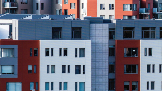 Aerial view of a modern apartment complex with a distinctive red and white facade and grey paneling in Delft Netherlands. Aerial view of a modern apartment complex with a distinctive red and white facade and grey paneling in Delft Netherlands.