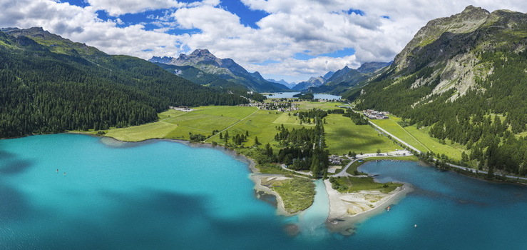 Aerial view of Surlej and the village of Silvaplana nestled between the turquoise waters of Lake Silvaplana and lush green alpine meadows in the Grisons Switzerland.