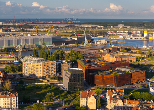 Aerial view of the Museum of the Second World War and the historic Gdansk Shipyard with modern buildings industrial cranes and the river in Gdansk Pomeranian Voivodeship Poland. Aerial view of the Museum of the Second World War and the historic Gdansk Shipyard with modern buildings industrial cranes and the river in Gdansk Pomeranian Voivodeship Poland.