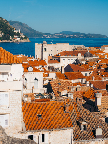 View of the iconic red tiled rooftops of the historic old town overlooking the Adriatic Sea and distant mountains in Dubrovnik Dubrovnik Neretva County Croatia. View of the iconic red tiled rooftops of the historic old town overlooking the Adriatic Sea and distant mountains in Dubrovnik Dubrovnik Neretva County Croatia.