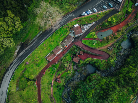Aerial view of winding red paths carving through lush green landscape leading to charming buildings and small ponds Achada Açores Portugal. Aerial view of winding red paths carving through lush green landscape leading to charming buildings and small ponds Achada Açores Portugal.