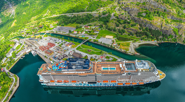 Flam Norway 18 June 2026 Aerial view of a large cruise ship docked at the port of Flam in the Aurlandsfjord surrounded by steep green mountains and village infrastructure. Flam Norway 18 June 2026 Aerial view of a large cruise ship docked at the port of Flam in the Aurlandsfjord surrounded by steep green mountains and village infrastructure.